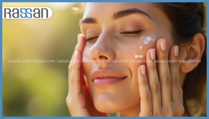 آیا ضد آفتاب لک صورت را از بین میبرد؟ 2 نمایی نزدیک از صورت خندان یک زن با چشمان بسته و مقداری کرم ضد آفتاب سفید روی پوست صورت